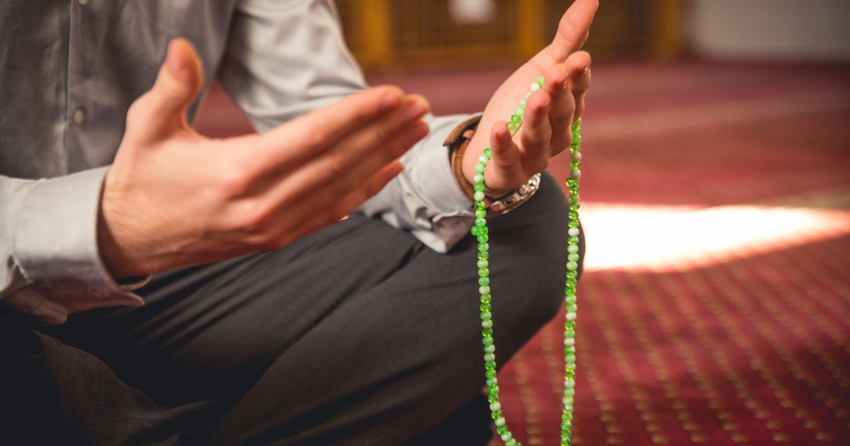 A graphic picture representing a muslim praying hand gesture with tasbih