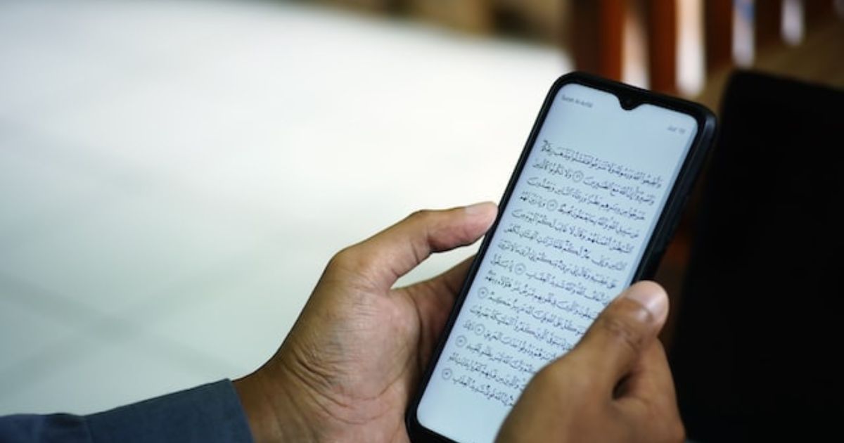 Muslim reading quran ayah via mobile phone